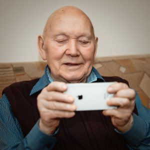 man in blue and black pinstripe dress shirt holding white smartphone