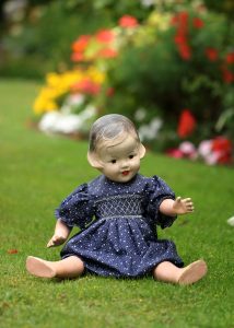 Used to be Simpler plastic girl doll sitting outdoor