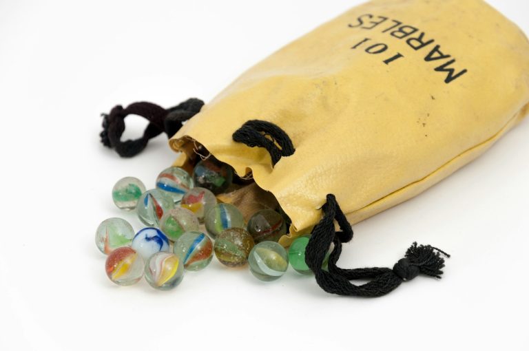 My marbles: marble toy lot near yellow drawstring pouch